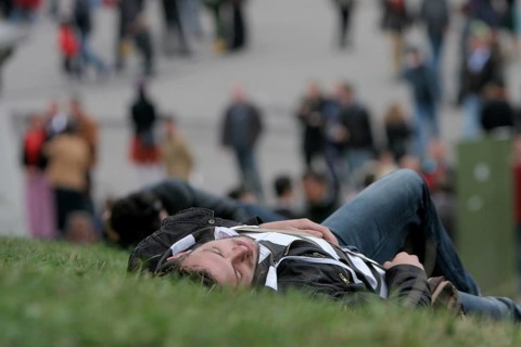 Young man sleeps off beer binge in a meadow