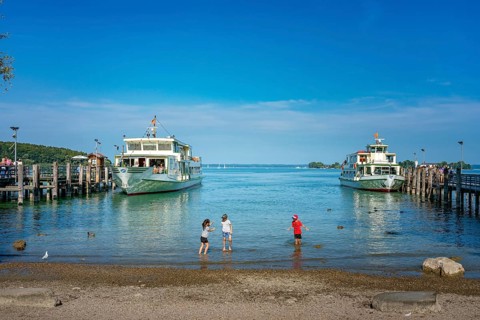 Children playing and ships at the jetty of Herreninsel