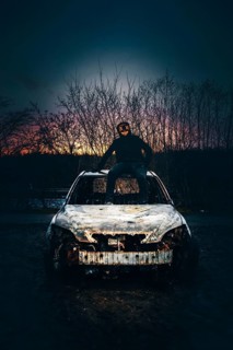 Man with Purge mask on a car wreck