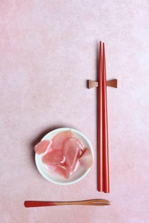 Pickled ginger slices in bowl and chopsticks