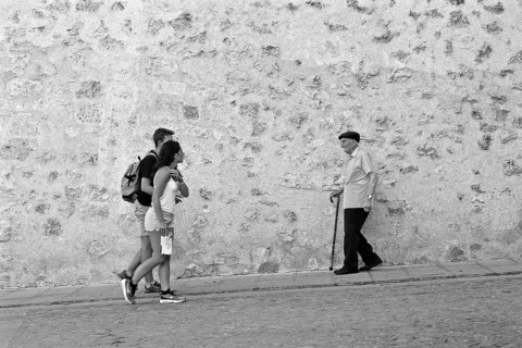 Young couple meets old man with cane