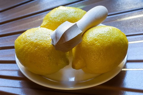 Three yellow lemons on a plate