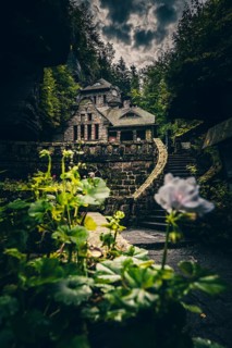 Old gasworks made of solid stone with stone steps in the middle of a gorge with forest and trees. Hrensko Czech Republic