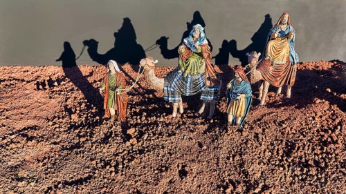 Nativity figures with camels cast shadows on a wall