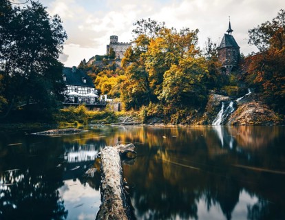 Pyrmonter mill at the waterfall of Elzbach with the castle Pyrmont in the back