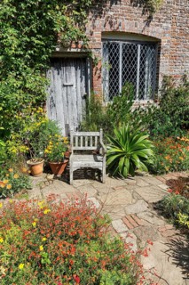 Cottage with garden chair in flowering front garden