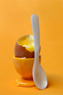 Soft boiled breakfast egg in egg cup with spoon