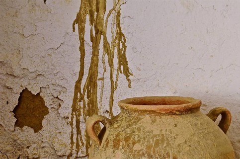 Old clay jug in front of dilapidated wall