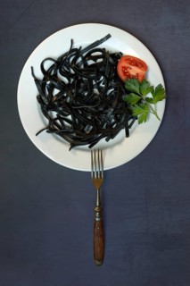Black pasta with squid ink on plate