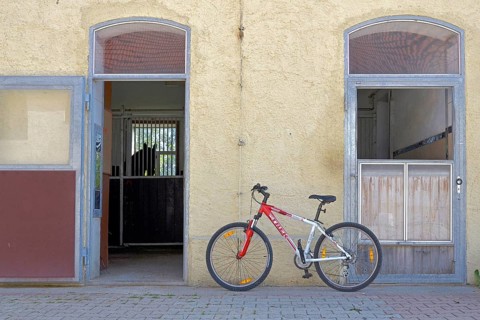 Bicycle leaning against wall in front of horse stable