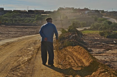 Old man on cane takes evening walk