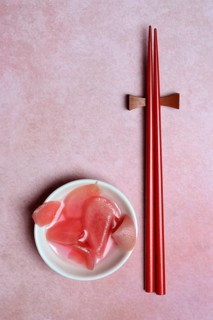 Pickled ginger slices in bowl and chopsticks
