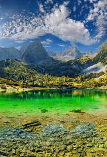 Turquoise Lake Seebensee and the mountain peak of the Tajakopf under a bizarre cloudy sky
