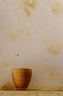 Clay jug in front of white wall in cave house