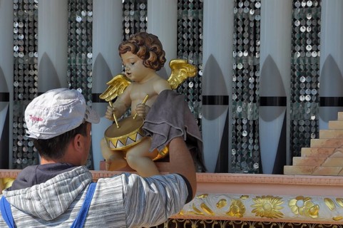 Man cleaning angel with drum from hurdy-gurdy at historic Oktoberfest