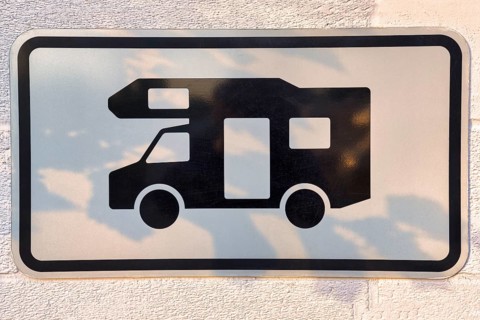 Sign with pictogram camper van on a wall