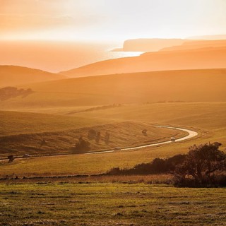 Winding country road overlooking the coast at sunset