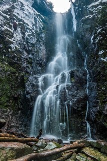The Burgbach waterfall in the middle of the green forest. Waterfall in Schapbach