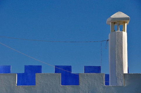 Chimney with white and blue battlements against the blue sky