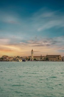 Sunset view over the sea to a Mediterranean town. St. Dionisius Church