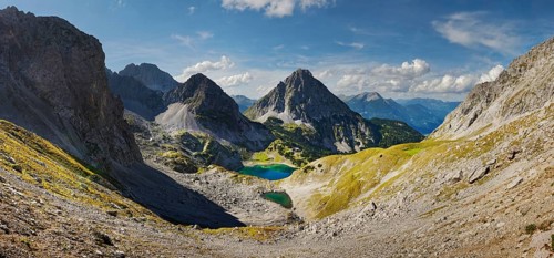 Mountain panorama above the Drachensee and the Coburger Huette with the mountain peaks of the Sonnenspitze