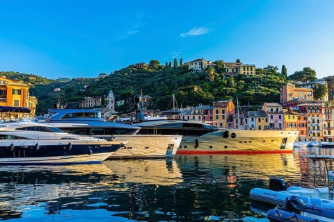 Luxury yachts anchor in the harbour of Portofino in the morning sun