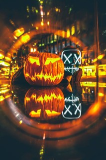 Man with Purge mask with Halloween pumpkin
