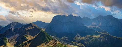 View from the summit of Gramaijoch to the Karwendel peaks of Lamsenjoch and Grubenkar under a cloudy evening sky