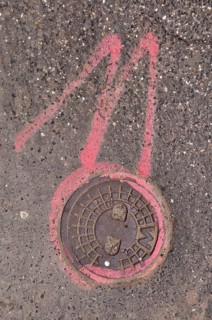 Manhole cover lid and number 11 in pink