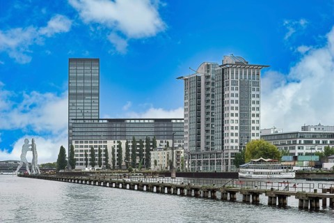 Modern buildings along the Spree river and Molecule Man behind