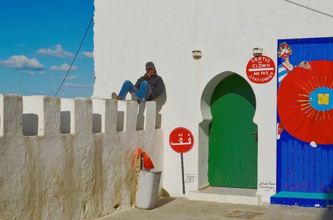Young man sunbathing on city wall