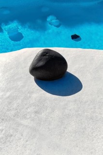 Rounded black lava stone at the edge of a pool