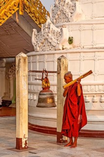 Monk ritually strikes a bell