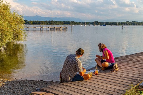 Man and woman sitting on the jetty in the evening