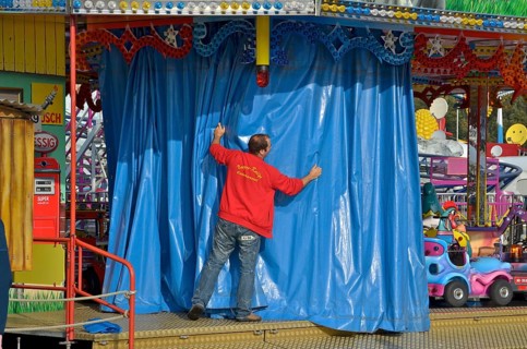 Showman draws curtain in front of his carousel