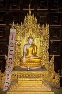 Buddha statue in teakwood monastery