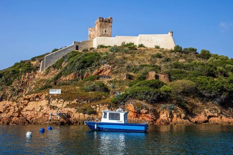 Genoese tower near the village of Girolata with staircase houses in the nature reserve of Scandola