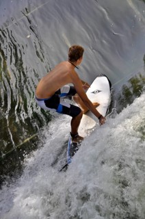 Standing surfer in the wave in the Eisbach at the Tierpark
