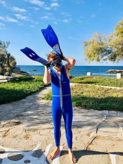 Young man in blue wetsuit diving goggles and snorkel