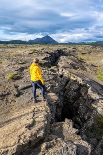 Woman standing at continental rift between North American and Eurasian Plates