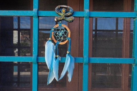 Andalusian Lucky Charm Indalo and Dreamcatcher on Iron Grille of Window