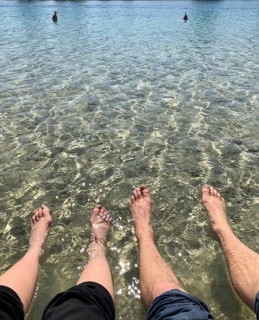 Two pairs of feet in the water
