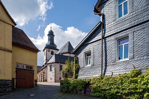 St. James Catholic Church among old clapboard houses made of wood and slate