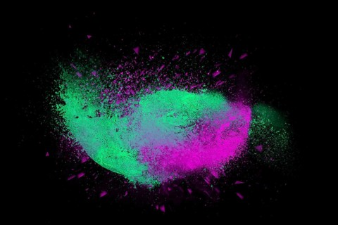 Freeze motion of colorful powder paint exploding isolated on black dark background. Abstract design of color dust cloud. Particles explosion screen saver