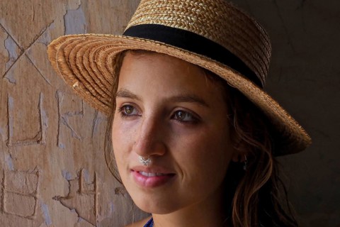 Young woman with straw hat and nose piercing sweats