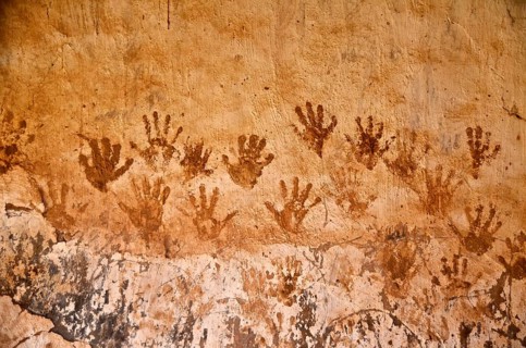 Handprints with henna on clay house wall