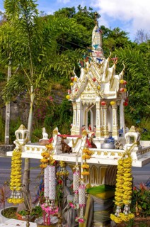 Buddhist spirit house Spirit house with offerings and floral decorations