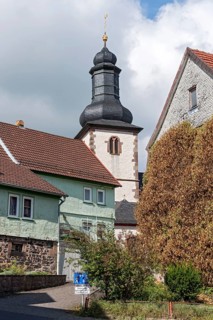 Bell tower of the Catholic Church of St. James between old clapboard houses