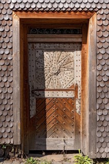 Old wooden door in dilapidated wooden clapboard house