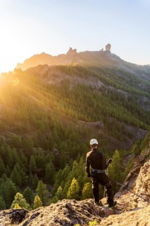 Man with professional gear doing rappelling sport in beautiful scenery of Roque Nublo mountain